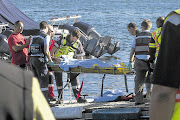 PLUCKED FROM THE SEA: A survivor is carried from the rescue vessel to a waiting ambulance after a tourist vessel capsized off Hout Bay