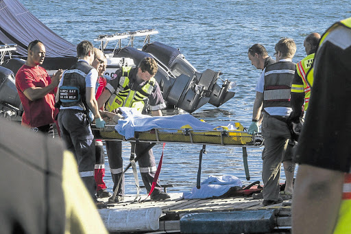 PLUCKED FROM THE SEA: A survivor is carried from the rescue vessel to a waiting ambulance after a tourist vessel capsized off Hout Bay