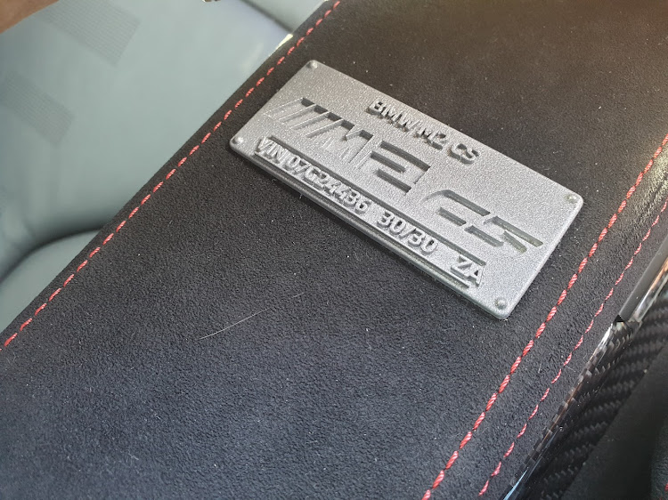 The numbered metal badge between the front seats identifies each M2 CS as part of a limited-edition series.