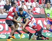 Matt Duffie of the Blues tackled by Aphiwe Dyantyi of the Lions and Ross Cronje of the Lions during the Super Rugby match between Emirates Lions and Blues at Emirates Airline Park on March 10, 2018 in Johannesburg, South Africa. 
