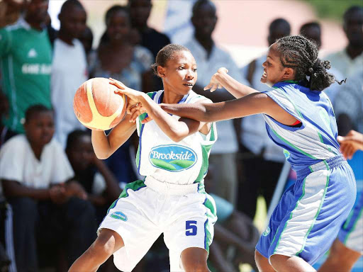 Mary Anne Aloo of Shimba Hills (L) shields the ball from Rebecca Daniel of Parklands Arya during their (KSSSA) Kenya Secondary Schools Sports Association term 1 national games Basketball final at Shimo Latewa School on April 19, 2014.Shimba won 67-42.Photo/Mohammed Amin/Piccentre.(KENYA)