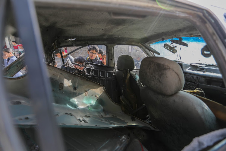 Children inspect a car that was destroyed by Israeli air strikes on March 2, 2024 in Rafah, Gaza.