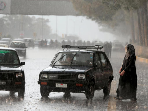Taxis stop to offer a ride to a woman standing in the rain in Islamabad, Pakistan March 1, 2017. /REUTERS