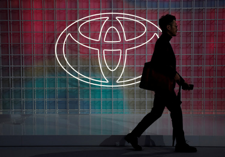 A man walks past a Toyota logo at the Tokyo Motor Show, in Tokyo, Japan. REUTERS/EDGAR SU/FILE