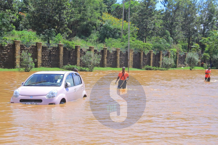 Rescuers try to remove a car that has been stuck in the waters at Kenyatta University area on Wednesday, May 1, 2024.