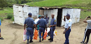 KZN police officers carry groceries to the home of a gogo in Umbumbulu, after her granddaughter asked officers for help when she was kicked out of her mother's house following an argument.