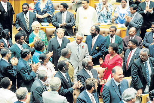 PROUD INSITUTITION: President Nelson Mandela greeted warmly by MPS across political lines in February 1996. Behind him are the senate president, Kobie Coetsee, speaker Frene Ginwale and Cyril Ramaphosa Picture: FILE