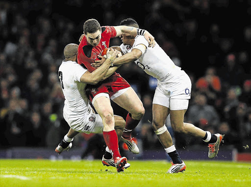 DAZED AND CONFUSED: George North of Wales is tackled by Jonathan Joseph and Anthony Watson of England during the match in which he was allowed to play on after losing consciousness