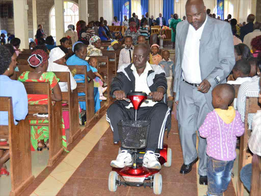 John wainaina Karamba drives his new electric wheel chair donated by Daniel Munyambu a former councillor in the UK at Icaciri PCEA church in Gatundu South.