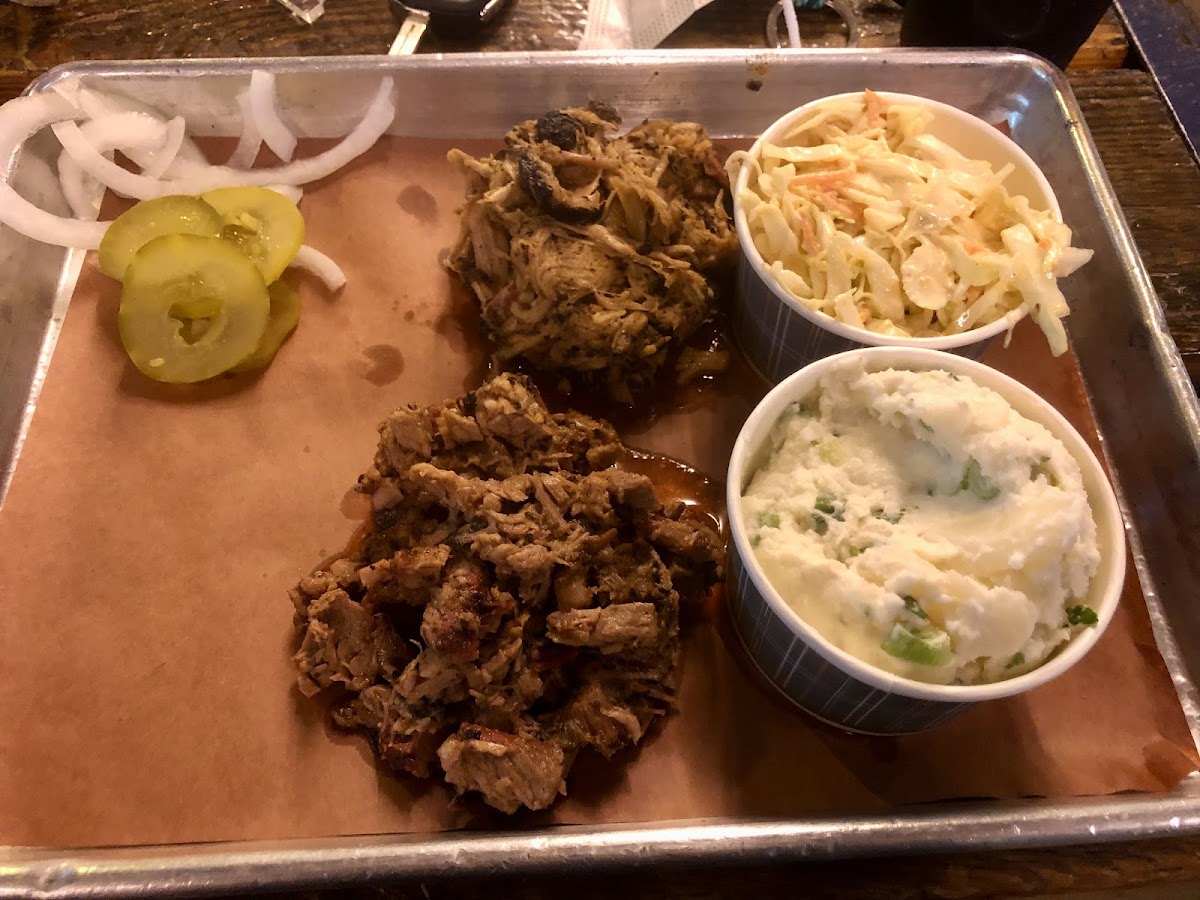 Two meat platter with chopped brisket and pulled pork. Sides: slaw and potato salad