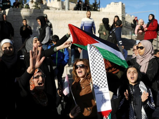 Palestinians hold flags as they take part in a protest against US President Donald Trump's decision to recognise Jerusalem as the capital of Israel, near Damascus Gate in Jerusalem's Old City December 11, 2017. /REUTERS