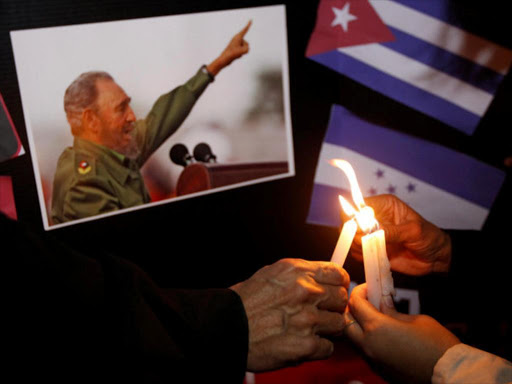 People place candles beside a picture of Fidel, as part of a tribute, following the announcement of the death of Cuban revolutionary leader Fidel Castro, in Tegucigalpa, Honduras November 26, 2016. REUTERS