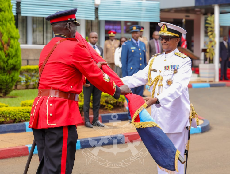 Chief of Defence Forces (CDF) General Charles Kahariri receives the KDF Flag during a change of guard at the Department of Defence in Nairobi on May 7, 2024.