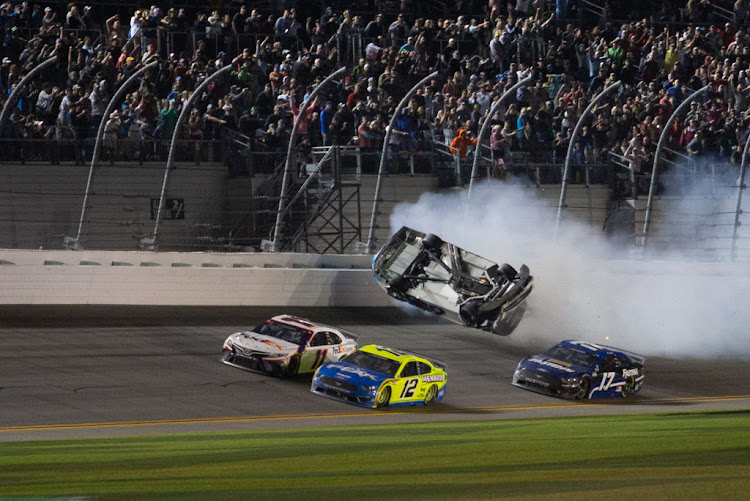 Ryan Newman, driver of the #6 Roush Fenway Racing Koch Industries Ford Mustang, crashes as Denny Hamlin, driver of the #11 Joe Gibbs Racing FedEx Express Toyota Camry, and Ryan Blaney, driver of the #12 Team Penske Menards/Peak Ford Mustang, race to the checkered flag during the Daytona 500 on February 17 2020 at Daytona International Speedway in Florida.