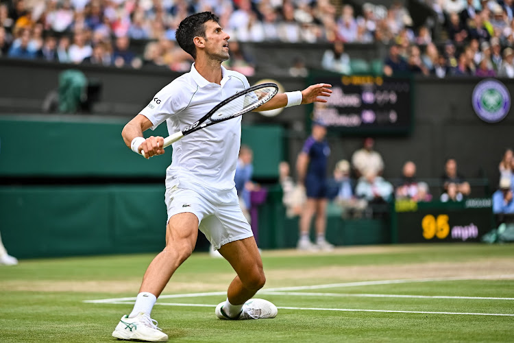 Novak Djokovic of Serbia hits a forehand against Dennis Shapovalov of Canada in the semifinals of the men's singles on day 11 of The Championships - Wimbledon 2021 at the All England Lawn Tennis and Croquet Club on July 09, 2021.