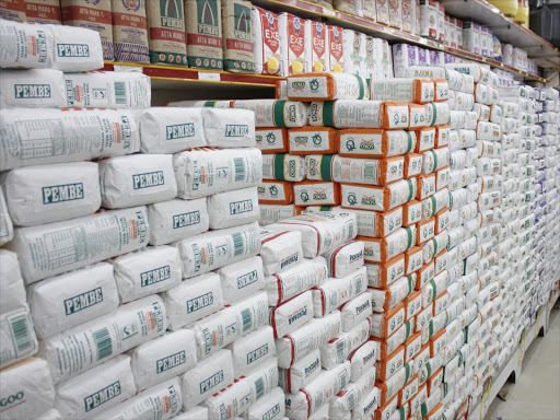 A shop attendant puts in place packets of maize flour in a supermarket shelf.pic\file