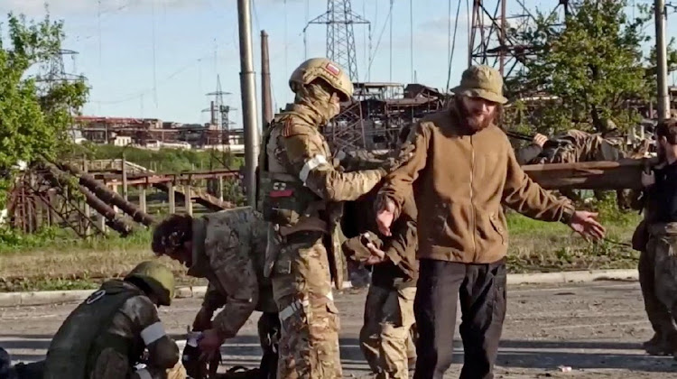 An image taken from a video released by the Russian defence ministry shows what it claims are service members of Ukrainian forces, who left the besieged Azovstal steel plant, being searched in Mariupol, Ukraine. Picture: RUSSIAN DEFENCE MINISTRY/REUTERS