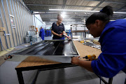 Workers in Atlantis, north of Cape Town, assemble solar panels in a factory that also produces LED lights. Manufacturing, the economy’s fourth-biggest sector, is expected to have contributed positively to GDP in the second quarter.