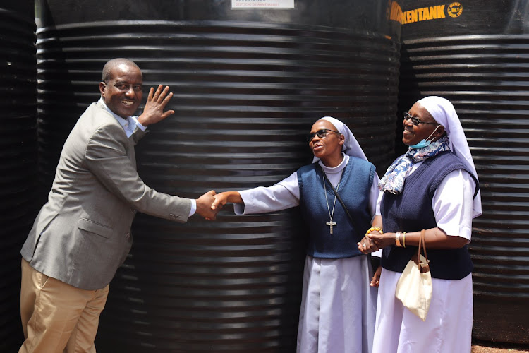 CECM water, environment and natural resource Malicha Boru handing over tank to one of the institution in Saku that benefitted from tanks distribution on Thursday at department office.