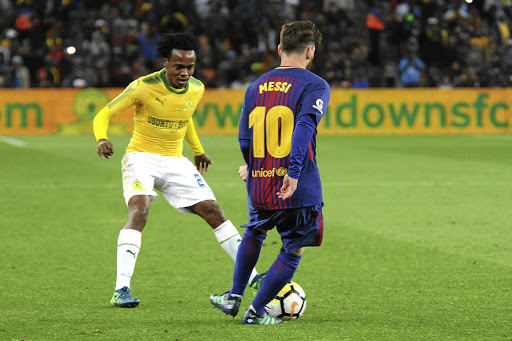 Sundowns star Percy Tau keeps a close eye on Barcelona's Lionel Messi during their friendly match at FNB Stadium last night.