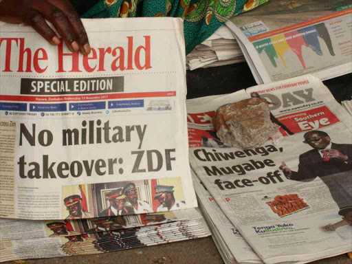 A vendor picks up a copy of a special edition of the state-owned daily newspaper The Herald in Harare, Zimbabwe November 15, 2017. /REUTERS