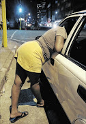 UNDERWORLD: A prostitute leans through a car window to talk to a potential customer. People, buying drugs from dealers or looking for employment, are often abducted and sold as sex slaves Photo: Gallo Images