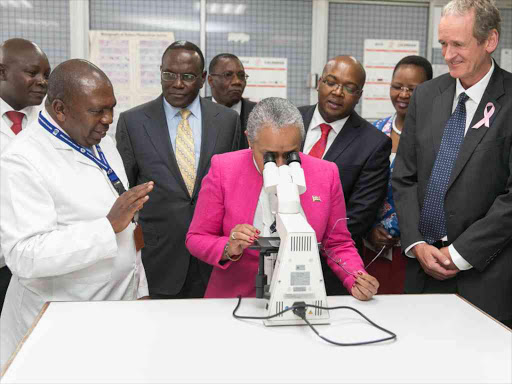 First Lady Margaret Kenyatta views a cancerous cell sample during the inauguration of a partnership to improve breast cancer management in Kenya at Kenyatta National Hospital in Nairobi, August 2016. /VICTOR IMBOTO