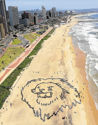 Hundreds of youths form a giant image of a lion's face on Addington Beach in Durban calling for urgent action on climate change.