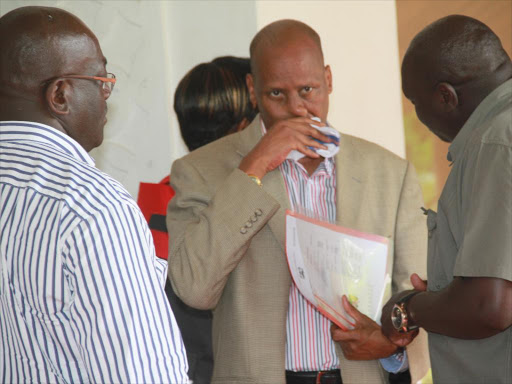 State house Comptroller Lawrence Lenaiyapa wipes his face as he confers with other officials in this file photo /ELKANA JACOB