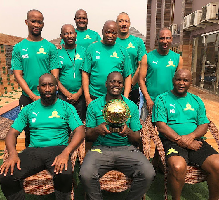 Mamelodi Sundowns goalkeeper Denis Onyango holds his Caf award trophy surrounded by his technical team.