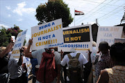 Foreign journalists hold banners as they march to the Egyptian Embassy in Nairobi,