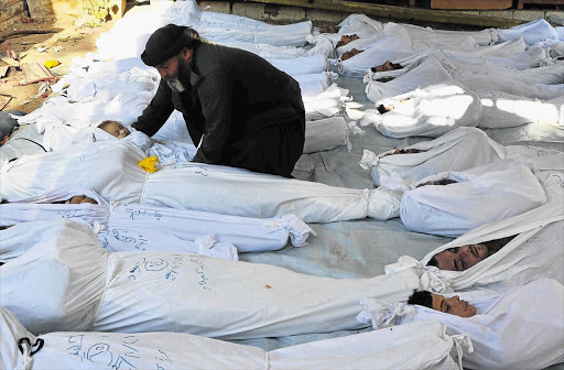 A dead Syrian child among the bodies of people killed in a suspected nerve-gas attack in the Duma neighbourhood of Damascus yesterday. Syrian activists said many women and children were among the fatalities as President Bashar al-Assad's forces attacked rebel-held districts