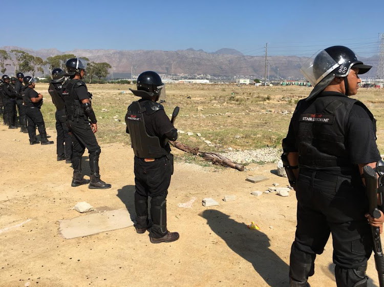 Members of the Red Ants monitor would-be land invaders in Lwandle near Strand, on April 11 2019.