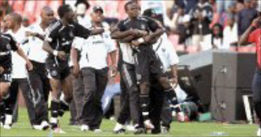 DEFIANT: Pirates' Isaac Chansa is restrained by his teammates and officials after being sent off in their game against Jomo Cosmos on Saturday. Pic. Antonio Muchave. 26/11/06. © Sowetan.