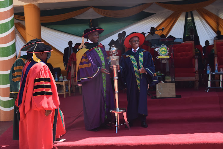 Outgoing Meru University Chancellor James Mwangi and Incoming Chancellor Peter Ndegwa while handing over the mace at Meru University