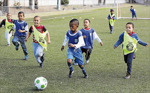 FUTURE STARS: Youngsters learn new skills with EL Central technical director Charles Pretorius (centre) taking the lead during the launch of a junior soccer academy at North End Stadium over the weekend Pictures: ALAN EASON