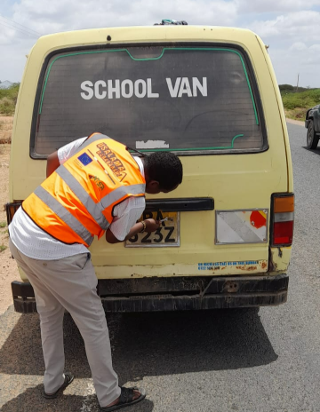 NTSA officer removes number plate from a motor vehicle during road safety compliance checks along the Garissa - Nairobi highway, March 27, 2024.