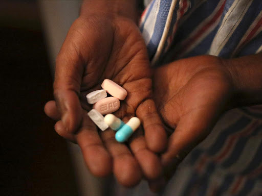 A patient holds antiretroviral (ARV) pills before taking his medication./FILE