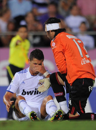 Cristiano Ronaldo (L) of Real Madrid reacts besides goalkeeper Dudu Aouate of Mallorca during the La Liga match between Mallorca and Real Madrid at the ONO Estadio on August 29, 2010 in Palma de Mallorca, Spain. Ronaldo picked up an injury during the match which will sideline the Portuguese star player for approximately three weeks