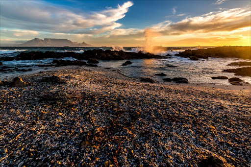 A late-afternoon scene at Big Bay, Western Cape, with the iconic Table Mountain and Lions Head in the fading light.