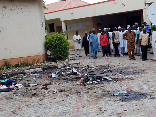 A file photo of journalists and other government officials gathering at the scene of a bomb blast, at Sabon-Gari Local Government Secretariat on the outskirts of the city of Zaria, in Kaduna, Nigeria July 7, 2015. /REUTERS