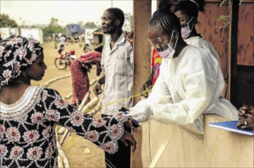 BATTLE CONTINUES : A file picture taken on March 28 shows Sierra Leone's health officials checking passengers transiting at the border crossing with Liberia in Jendema PHOTO: ZOOM DOSSO/ AFP