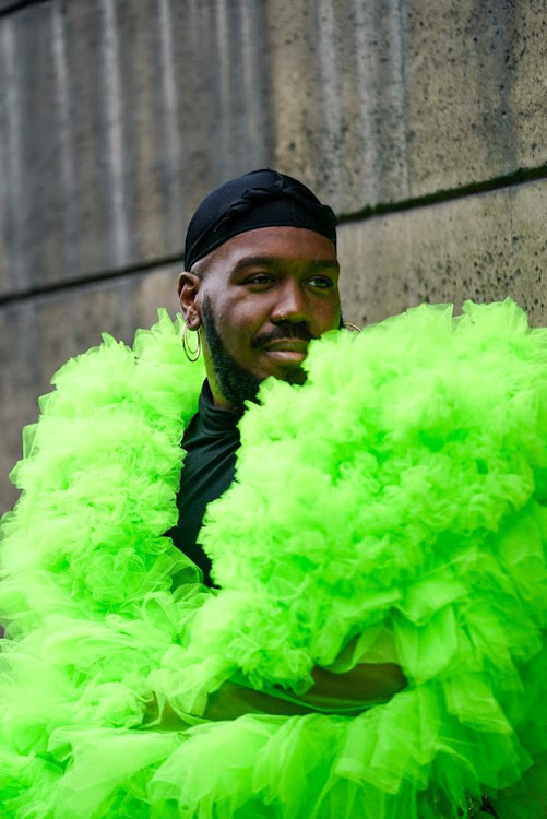 Kiddy Smile wears a black beanie hat, earrings, a neon-green tulle frilly coat, during Paris Fashion Week on March 2.