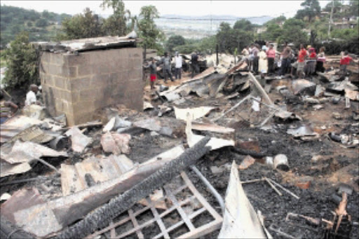 BURNT: Ezimileni residents in Umlazi section V were in shock after a candle left burning by a resident allegedly started a fire that swept through several dwellings, destroying them and their contents on Saturday night. Pic: Thuli Dlamini. 28/03/2010. © Sowetan.