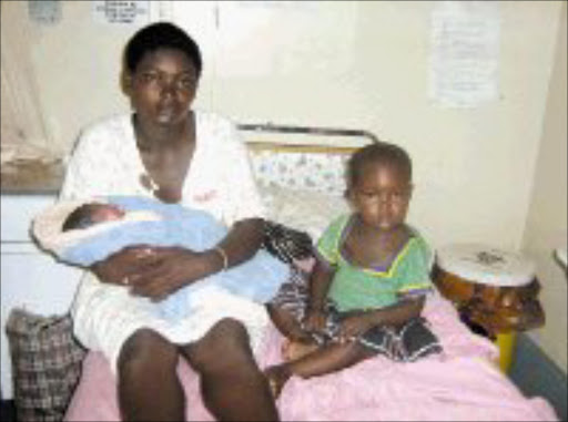 YOUNG FAMILY: Bridget Mabasa, 20, holds the newborn girl she gave birth to on the street. Her two-year-old daughter sits next to her on the hospital bed. Pic. Victor Hlungwani. 23/01/2007. © Unknown.