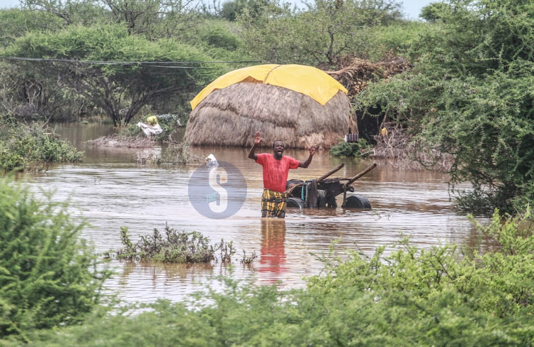 Ali Abdilahi Muhamad, a 50-year-old elder at Shimberey Village in Garissa County wades through water after being displaced by floods following heavy downpour in the area on April 26, 2024.