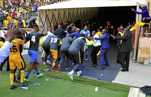 Kaizer Chiefs players cower from a hail of missiles thrown by fans after their 3-0 loss to Chippa United two weeks ago. Amakhosi have been fined R250 000.