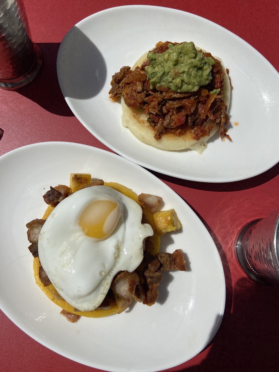 Delicious arepas for brunch! Yellow arepa w chicharron, sweet plantains, and a fried egg, and white arepa with ropa vieja and guacamole