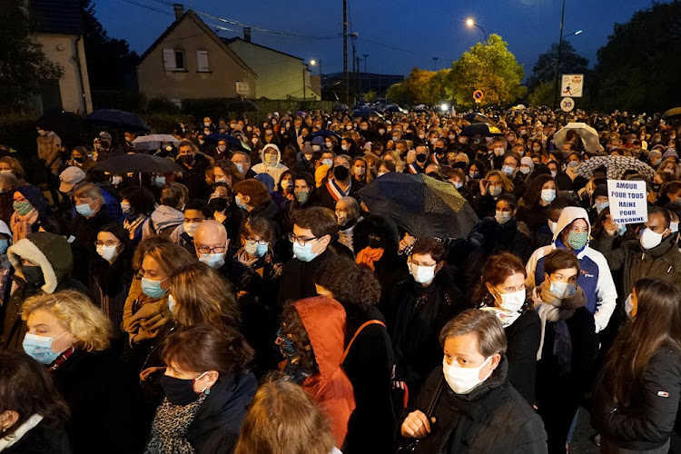 People attend a silent march to pay tribute to Samuel Paty, the French teacher who was beheaded on the streets of the Paris suburb of Conflans-Sainte-Honorine, France, October 20, 2020.