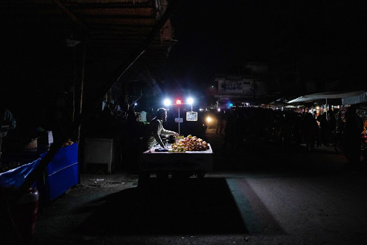 Vendors sell fruit under lights lit by batteries in Lahore, Pakistan, on January 23 2023. Millions of people across Pakistans major cities were plunged into a blackout prompted by a power grid failure, dealing another blow to the nation already reeling from surging energy costs. Picture: Betsy Joles/Bloomberg